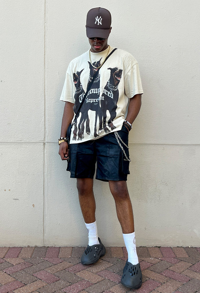 A stylish young black man poses in Hyper Denim's Black Leather Cargo Shorts